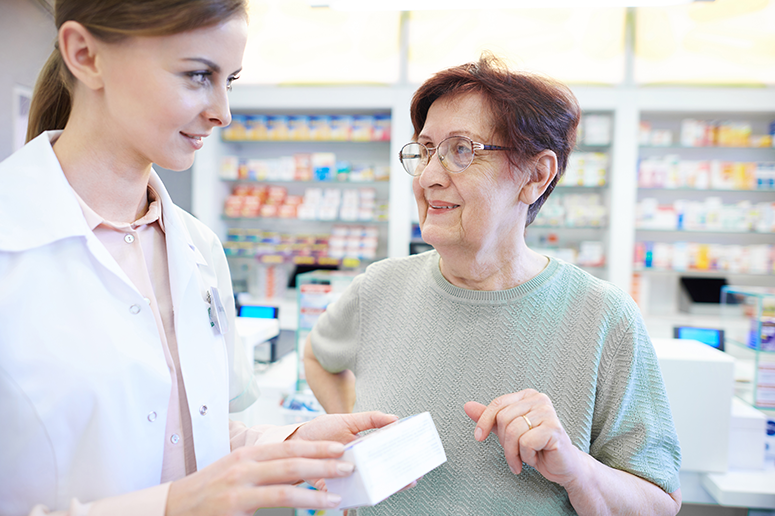 Pharmacist assisting older woman