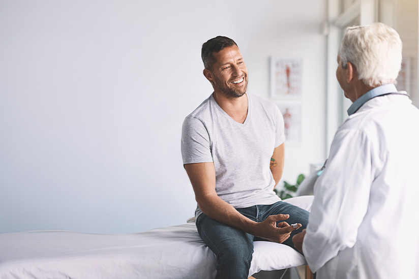 A man is discusses health with a doctor in a medical office setting