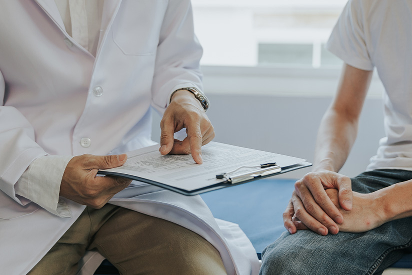 A doctor speaks with a patient, sharing information