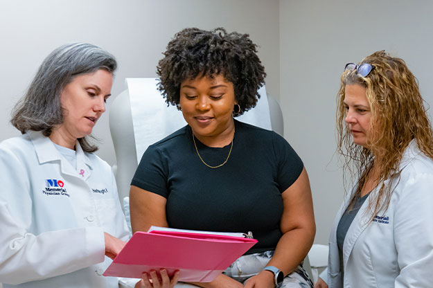 Breast cancer awareness, Doctor Heather Wright and patient navigator talking to patient